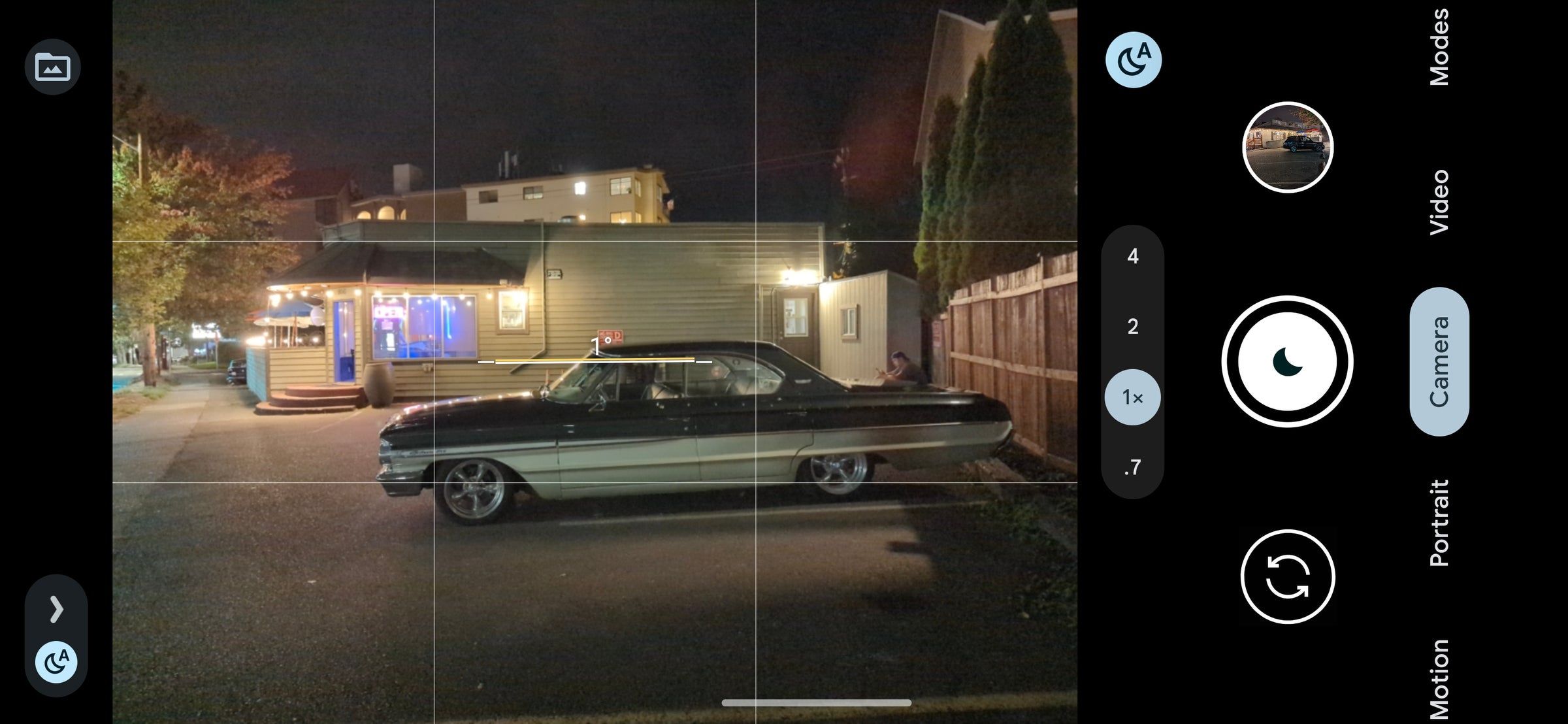 A dimly lit night scene with an old car.