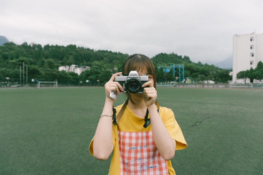 Woman taking a photo with a film camera